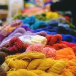 table piled with different colored skeins of yarn