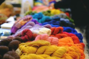 table piled with different colored skeins of yarn