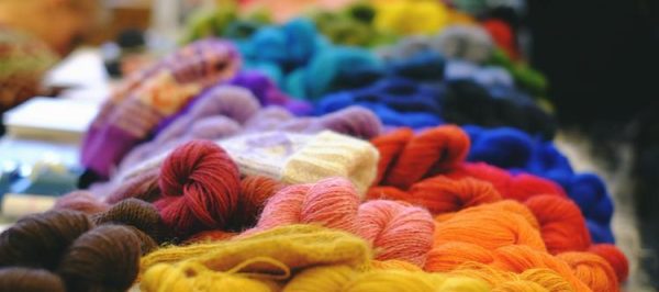 table piled with different colored skeins of yarn